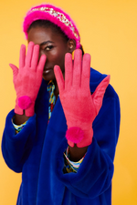 An image of a female model wearing the Jayley Suede Faux Pom Glove in the colour Magenta.