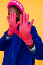 An image of a female model wearing the Jayley Suede Faux Pom Glove in the colour Magenta.