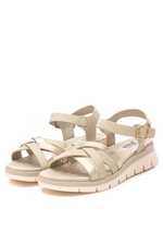 XTI Low Wedge Sandal. A pair of wedge sandals with intertwining metallic gold straps and gold buckle detail.