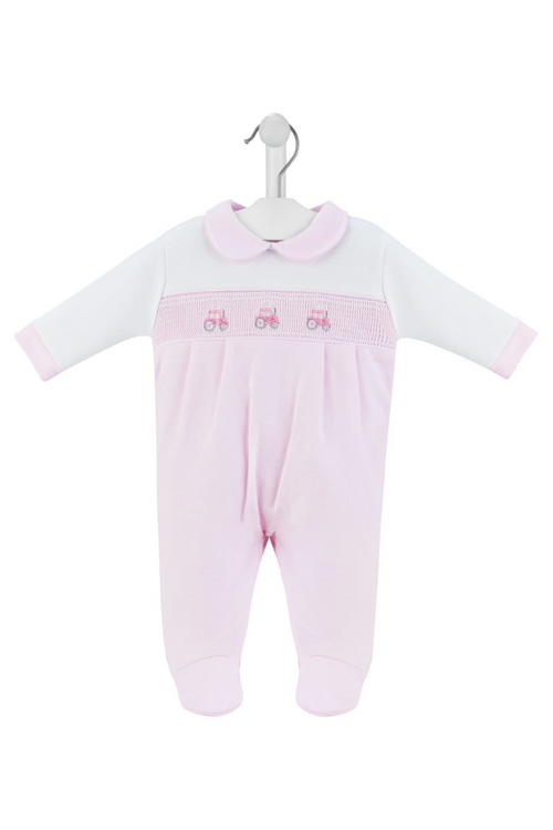 Dandelion Little Tractor Smock Sleepsuit. A long sleeve sleepsuit with peter pan collar, smocked detail and tractor embroidery. This sleepsuit is white and pink.