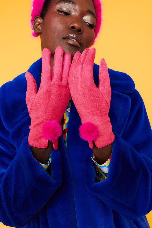 An image of a female model wearing the Jayley Suede Faux Pom Glove in the colour Magenta.
