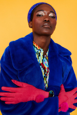 An image of a female model wearing the Jayley Suede Faux Pom Glove in the colour Magenta.