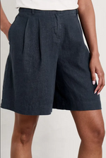 An image of a model wearing the Seasalt Clover Bloom Shorts in the colour Maritime.