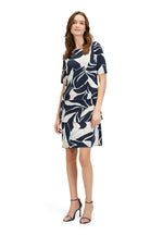 Betty Barclay Tiered Dress. A knee-length straight fit dress, with mid-length sleeves. This dress features an abstract print with pastel blue and pink accents on a navy background.