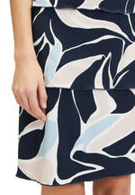 Betty Barclay Tiered Dress. A knee-length straight fit dress, with mid-length sleeves. This dress features an abstract print with pastel blue and pink accents on a navy background.