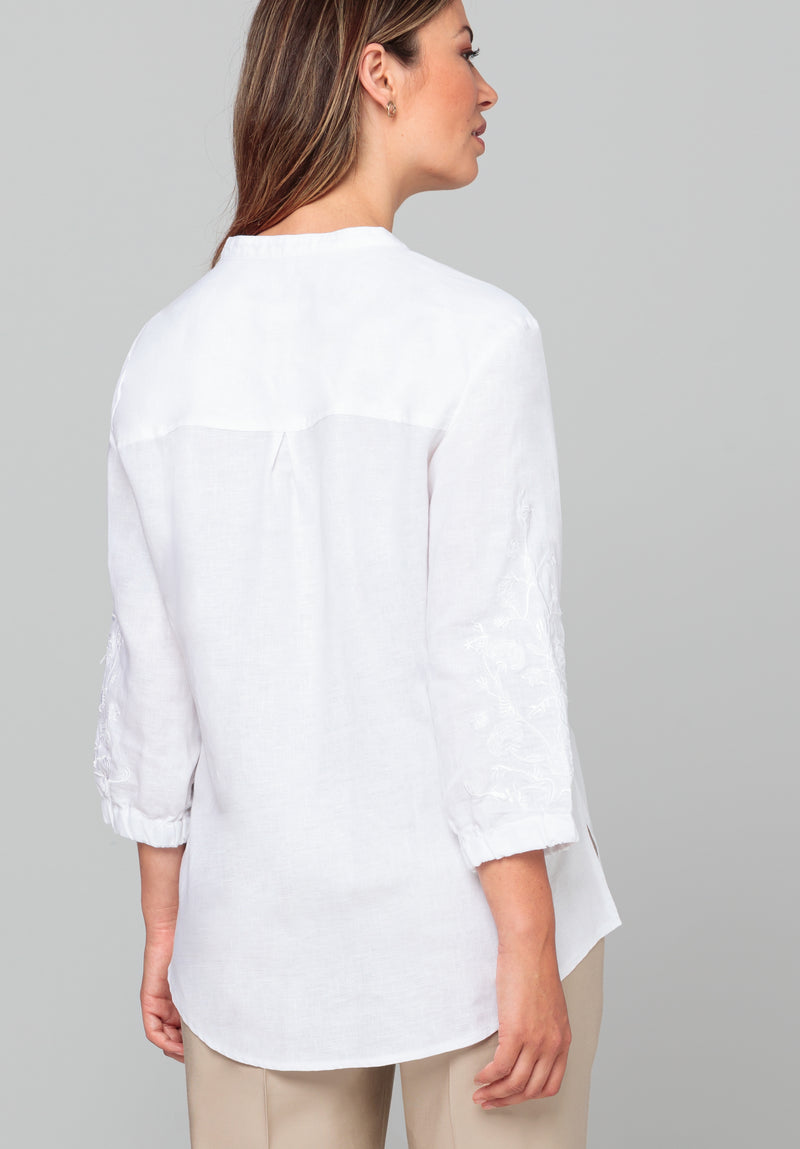 Bianca Linen Adela Blouse. A floaty white blouse with sleeves that fall above the wrist and V-neckline. This blouse also has detailing on the sleeves.