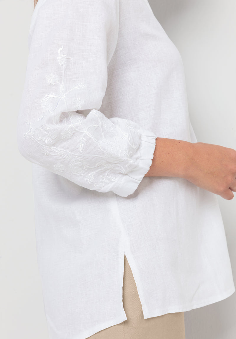 Bianca Linen Adela Blouse. A floaty white blouse with sleeves that fall above the wrist and V-neckline. This blouse also has detailing on the sleeves.