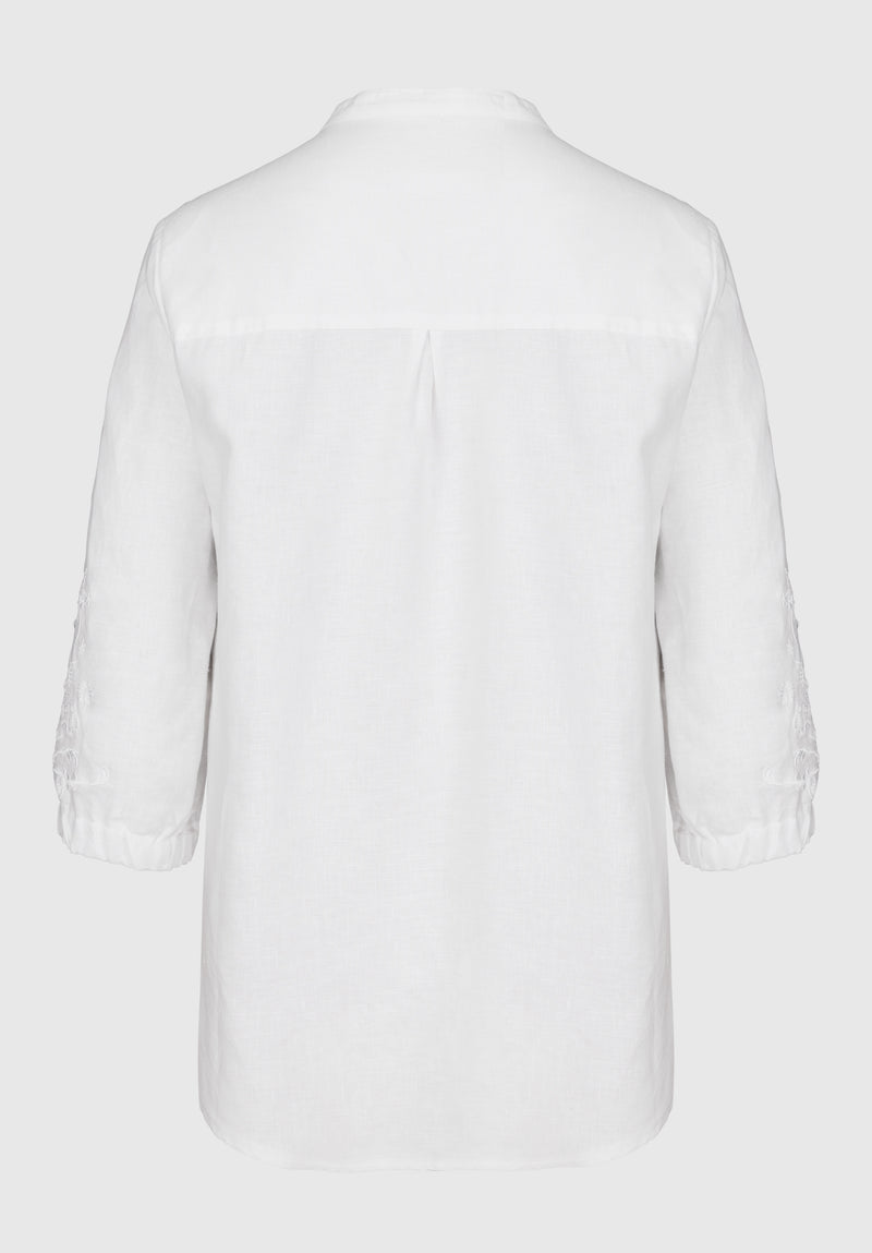 Bianca Linen Adela Blouse. A floaty white blouse with sleeves that fall above the wrist and V-neckline. This blouse also has detailing on the sleeves.