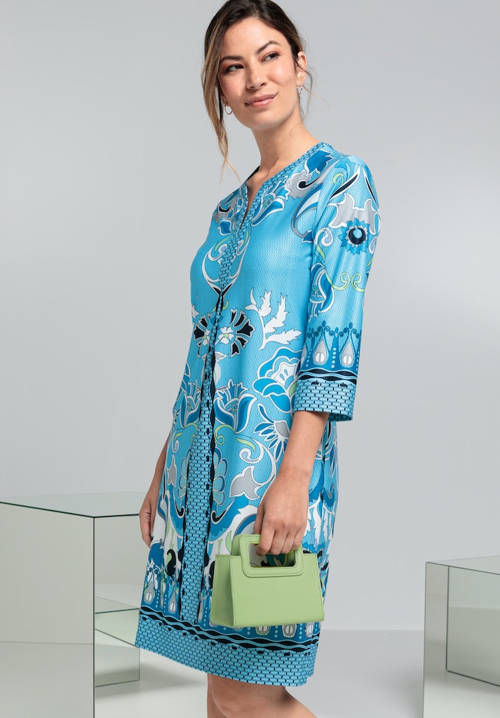 Bianca Danilo 3/4 Sleeve Patterned Dress. A relaxed fit dress with 3/4 length sleeves, knee-length design, and V-neckline. This dress has a vibrant blue pattern.