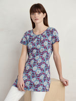 An image of a model wearing the Seasalt Countryside Jersey Tunic in the colour Stone Flower Saltwater.