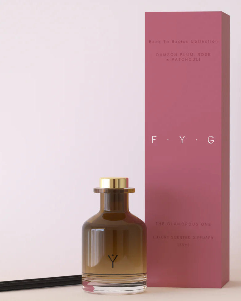 FYG diffuser bottle and packaging on a light pink background