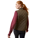 An image of a female model wearing the Ariat Woodside Quilted Gilet in the colour Earth.