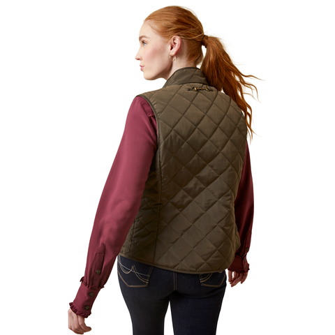 An image of a female model wearing the Ariat Woodside Quilted Gilet in the colour Earth.