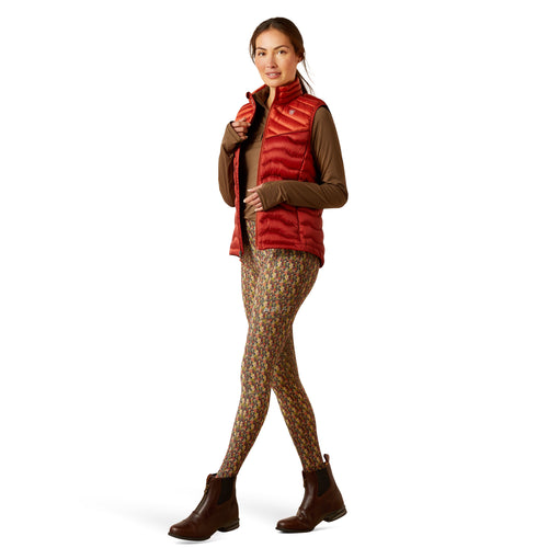 An image of a female model wearing the Ariat Ideal Down Gilet in the colour Iridescent Red.