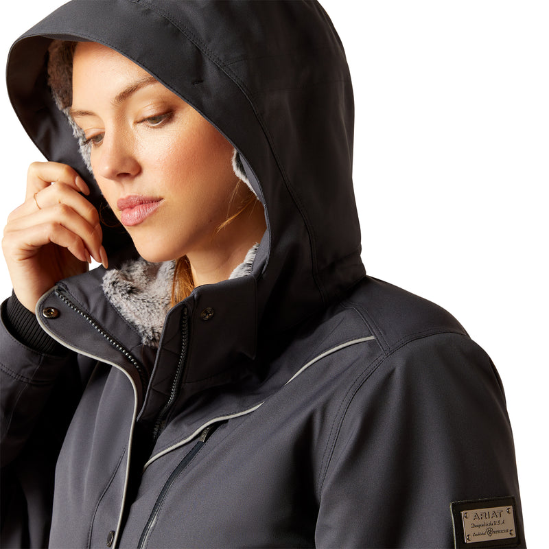 An image of a female model wearing the Ariat Tempest Waterproof Insulated Parka in the colour Ebony.