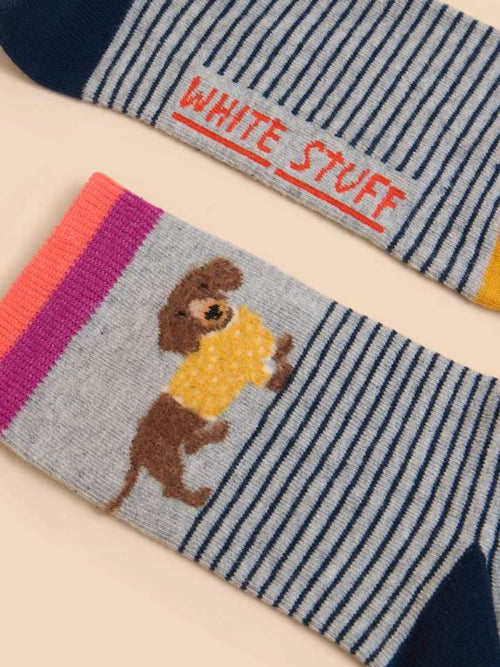 White Stuff Fluffy Sausage Dog Sock with striped design, yellow toe, navy heel and a cute sausage dog on the side.