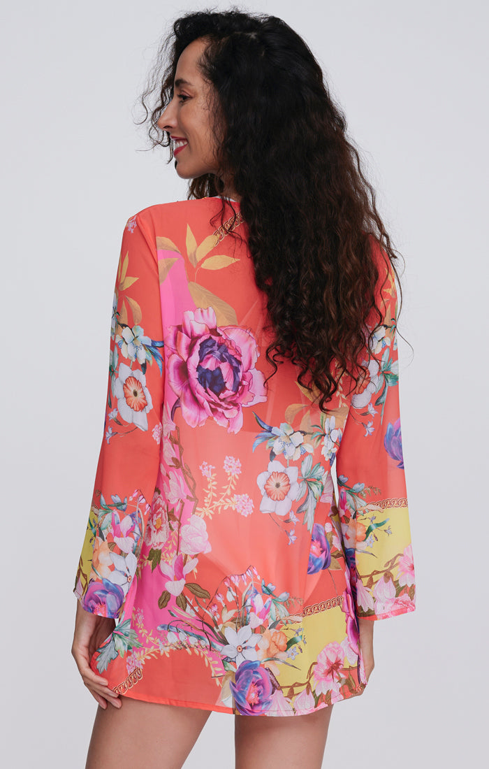 Pia Rossini Hawaii Cover Up. A midi-length, long sleeve cover up in a lightweight material, with V-neckline, dazzling embellishment and pink floral print.