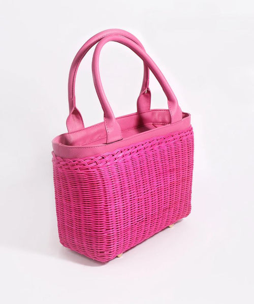 Pia Rossini Juno Bag. A bag made from rattan material with twin top handles and zip closure in a fuchsia colour. This bag has a fully lined interior and pockets.