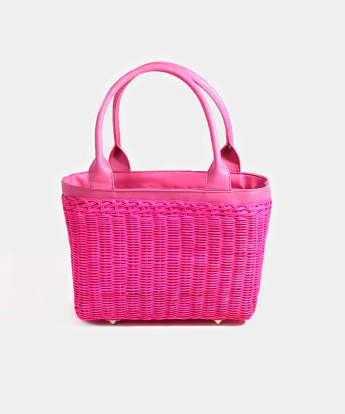 Pia Rossini Juno Bag. A bag made from rattan material with twin top handles and zip closure in a fuchsia colour. This bag has a fully lined interior and pockets.