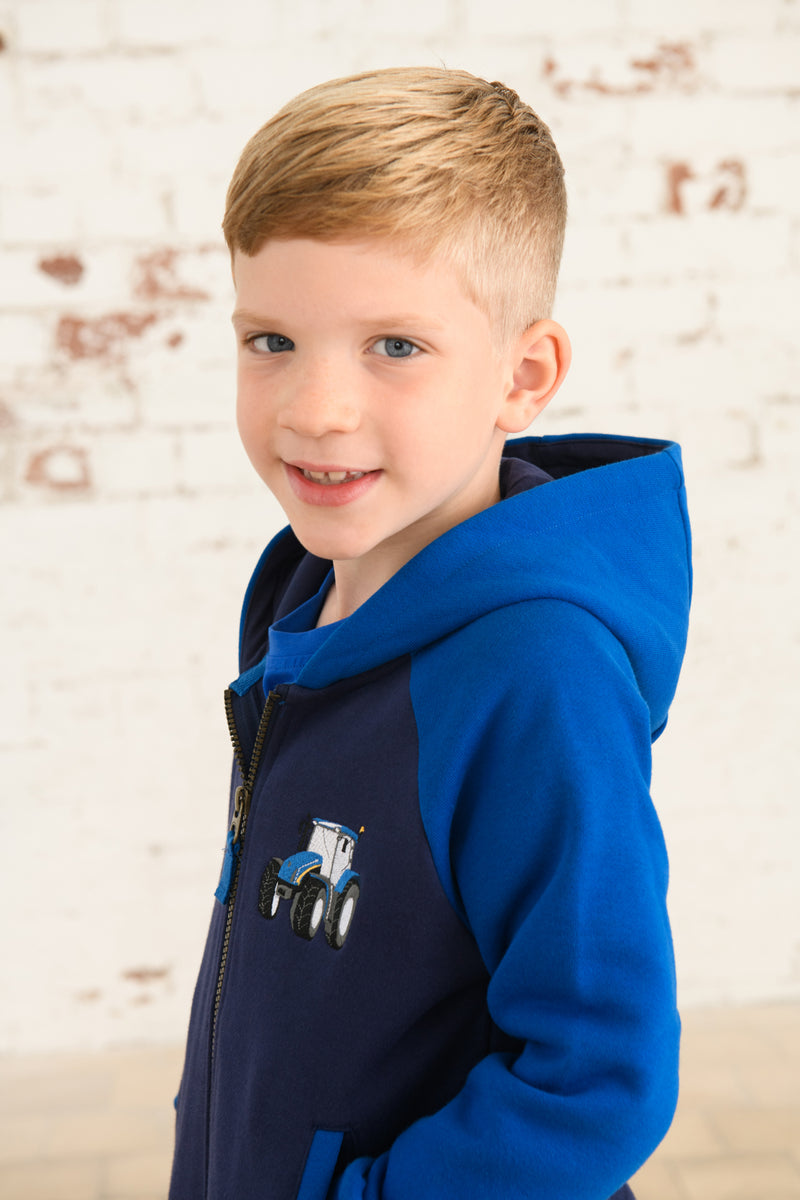 Lighthouse Jackson Full Zip Hoodie. A boys zip-up hoodie with waist pockets, a soft jersey lined hood, and a a navy torso with a tractor piqué on the chest and blue sleeves.