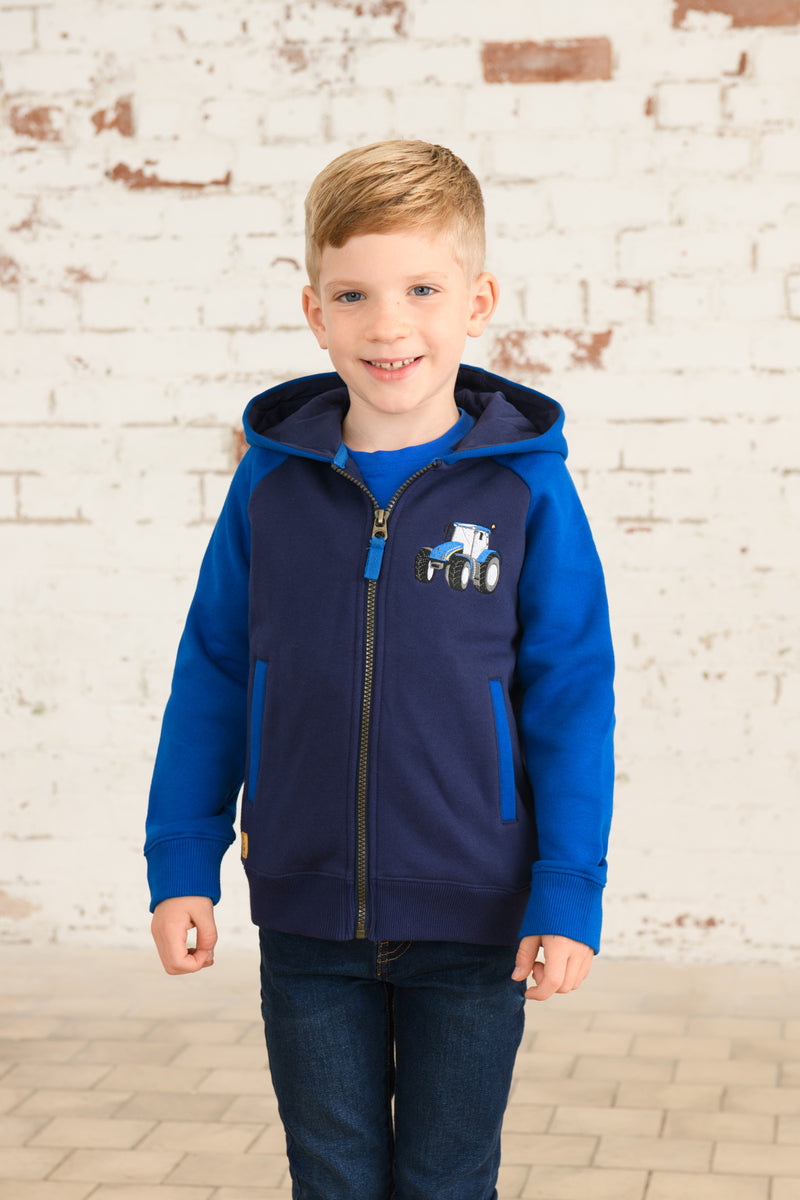 Lighthouse Jackson Full Zip Hoodie. A boys zip-up hoodie with waist pockets, a soft jersey lined hood, and a a navy torso with a tractor piqué on the chest and blue sleeves.