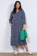 Lily & Me Sadie Terrazzo Dress. A relaxed fit shirt dress with bracelet length sleeves and tiered skirt. This dress has pockets and a navy ditsy print.