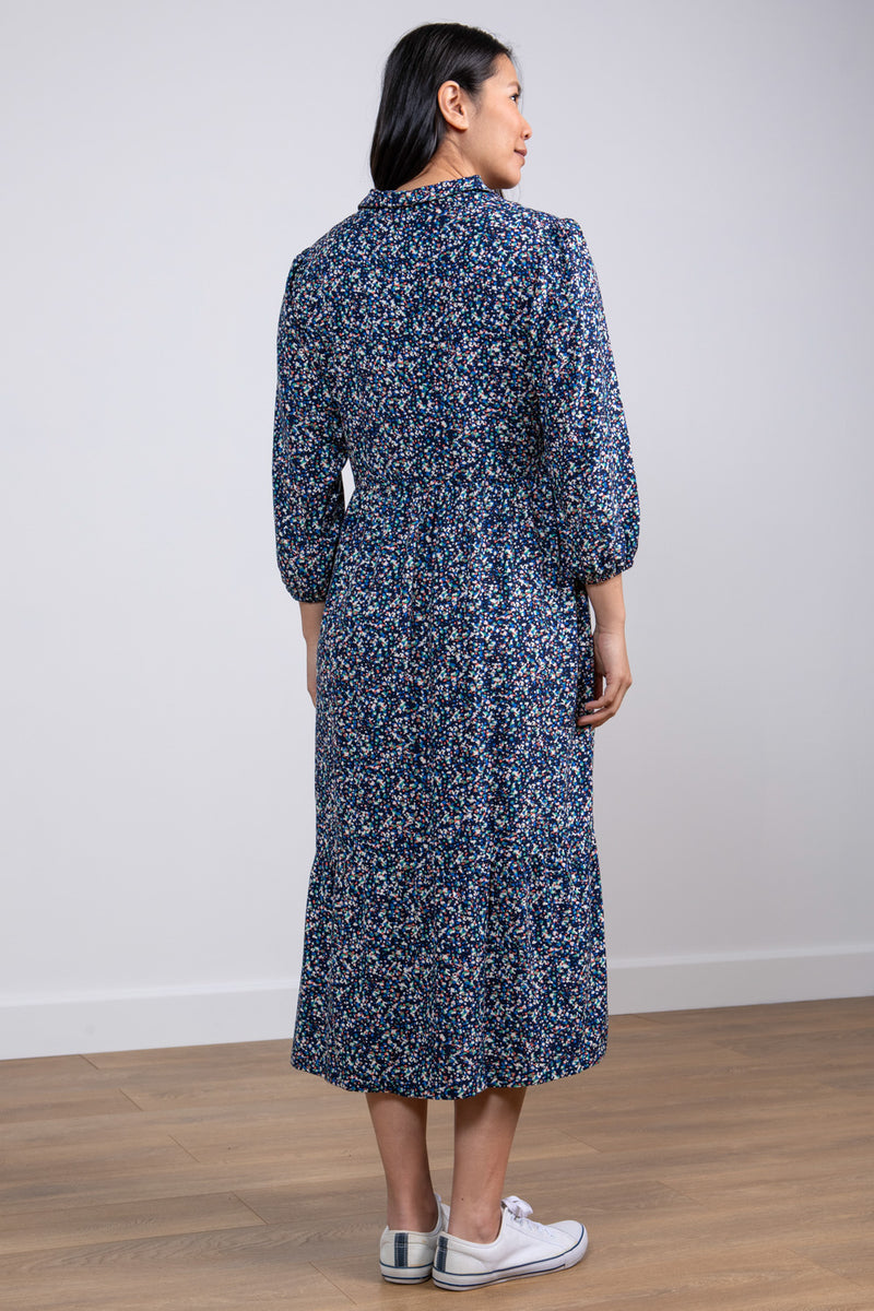 Lily & Me Sadie Terrazzo Dress. A relaxed fit shirt dress with bracelet length sleeves and tiered skirt. This dress has pockets and a navy ditsy print.