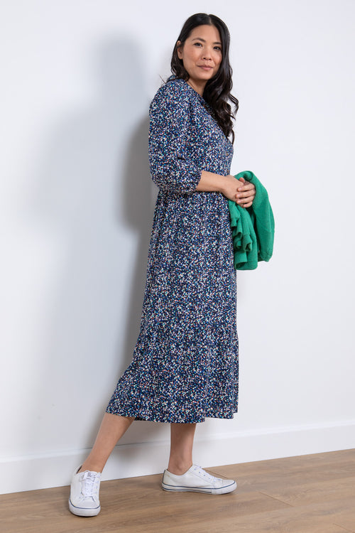 Lily & Me Sadie Terrazzo Dress. A relaxed fit shirt dress with bracelet length sleeves and tiered skirt. This dress has pockets and a navy ditsy print.