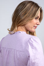 Lily & Me Spring Berkeley Top. A long sleeve, relaxed-fit top with V-neckline, neck ties and lace detail. This top is a lavender purple colour.