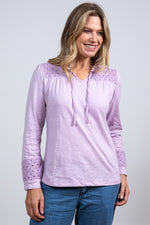 Lily & Me Spring Berkeley Top. A long sleeve, relaxed-fit top with V-neckline, neck ties and lace detail. This top is a lavender purple colour.