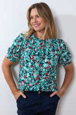 Lily & Me Frieda Lily Top. A peter pan collared top with short cuffed sleeves in a bold sea green print.