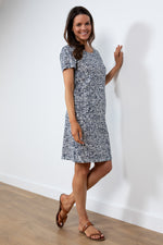 Lily & Me Calcot Dress Dapple. A knee-length dress with short sleeves, patch pockets, a feminine round neckline, and a chic navy linework print.