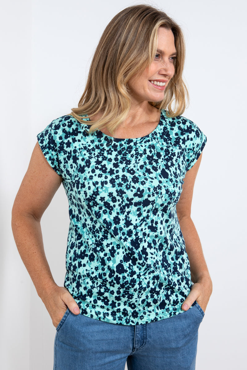Lily & Me Surfside Tee Confetti. A women's summer t-shirt with short sleeves, a curved hem, a feminine round neckline and a turquoise design with black flower detail.