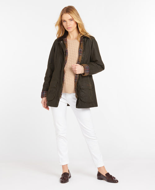 An image of a female model wearing the Barbour Classic Beadnell Wax Jacket in the colour Olive.