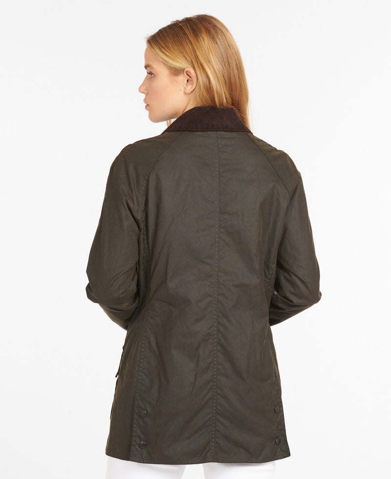 An image of a female model wearing the Barbour Classic Beadnell Wax Jacket in the colour Olive.