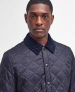 An image of a male model wearing the Barbour Heritage Liddesdale Quilted Jacket in the colour Navy.