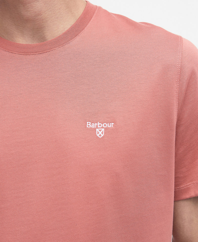 An image of a male model wearing the Barbour Men's Essential Sports T-Shirt in the colour Pink Clay.