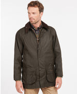 An image of a male model wearing the Barbour Classic Beaufort Wax Jacket in the colour Olive.