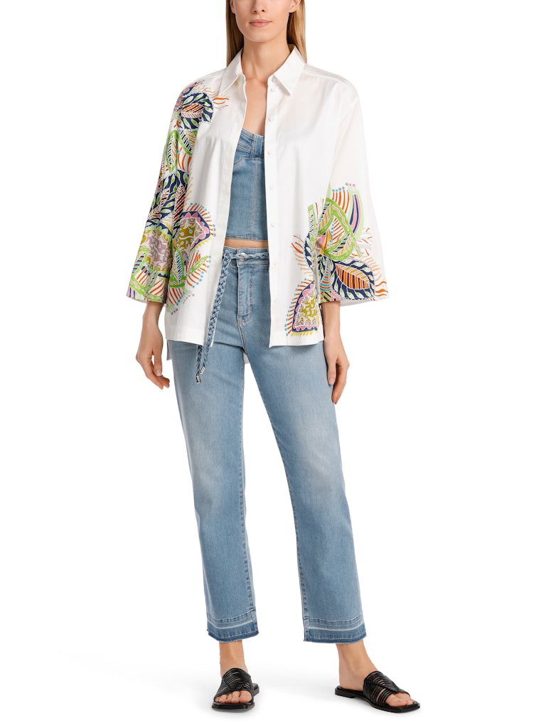 Marc Cain Beaded Floral Blouse. An A-line blouse with wide sleeves and kent style collar. This shirt has a multicoloured print with embroidery and a side seam slit.