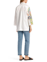 Marc Cain Beaded Floral Blouse. An A-line blouse with wide sleeves and kent style collar. This shirt has a multicoloured print with embroidery and a side seam slit.