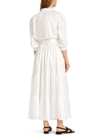 Marc Cain Tiered Maxi Dress. A maxi length dress with 3/4 length sleeves, tiered skirt and kent style collar. This dress is off-white and has a tie waist detail.