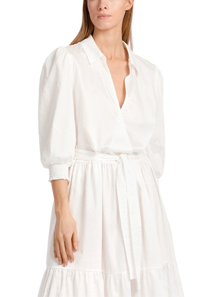 Marc Cain Tiered Maxi Dress. A maxi length dress with 3/4 length sleeves, tiered skirt and kent style collar. This dress is off-white and has a tie waist detail.