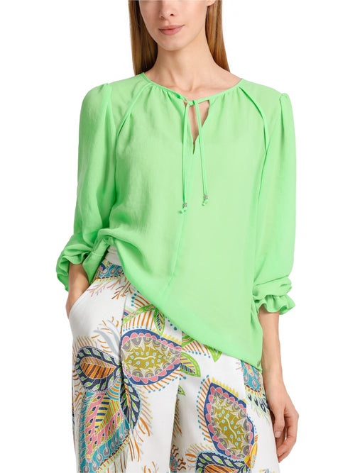 Marc Cain Blouse. An A-line blouse with long ham sleeves and tie neck detail. This blouse is light and airy and the colour is vibrant green.