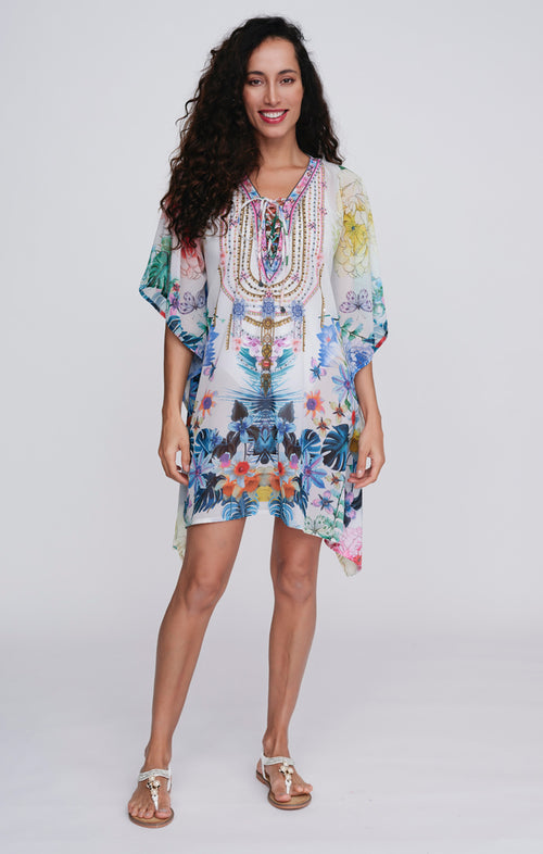 Pia Rossini Paradiso Cover Up. A mid-length, 3/4 sleeve cover up made of lightweight fabric with embellishment and multi-coloured floral print.