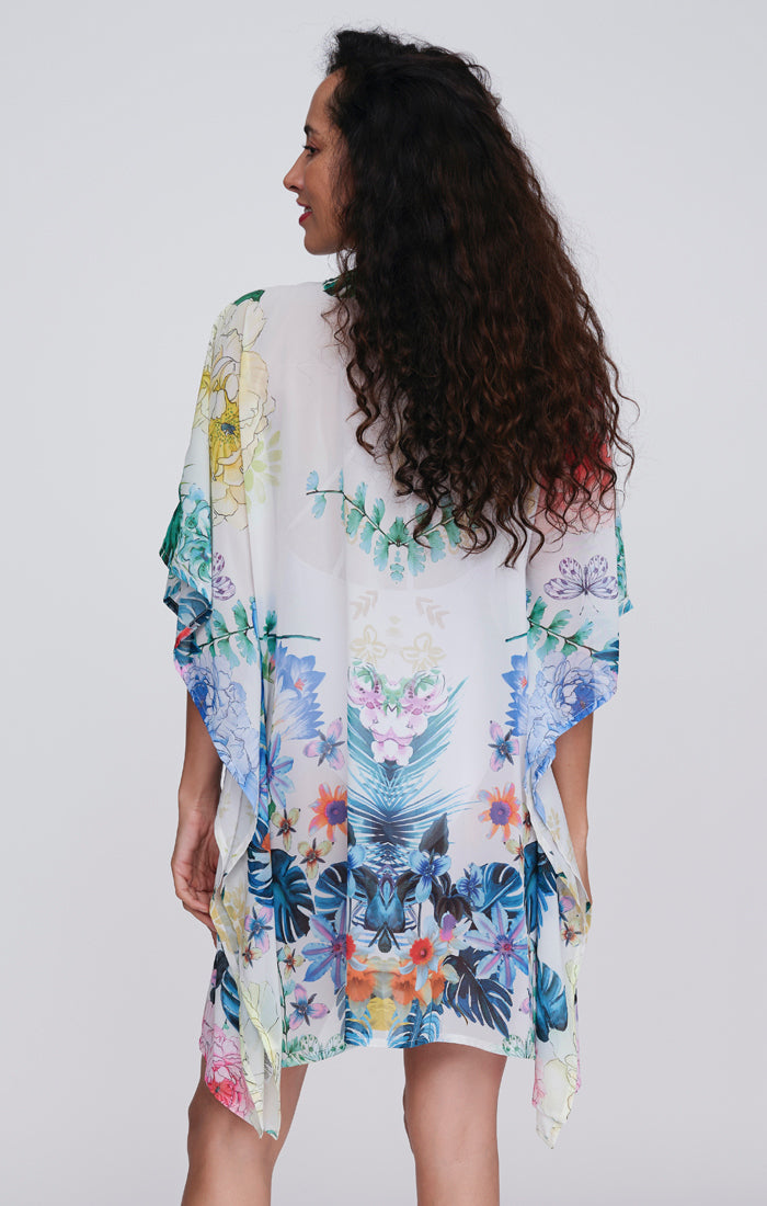 Pia Rossini Paradiso Cover Up. A mid-length, 3/4 sleeve cover up made of lightweight fabric with embellishment and multi-coloured floral print.
