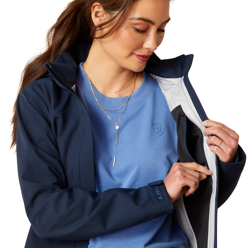 An image of a female model wearing the Ariat Coastal Long H20 Parka Jacket in the colour Navy Eclipse.