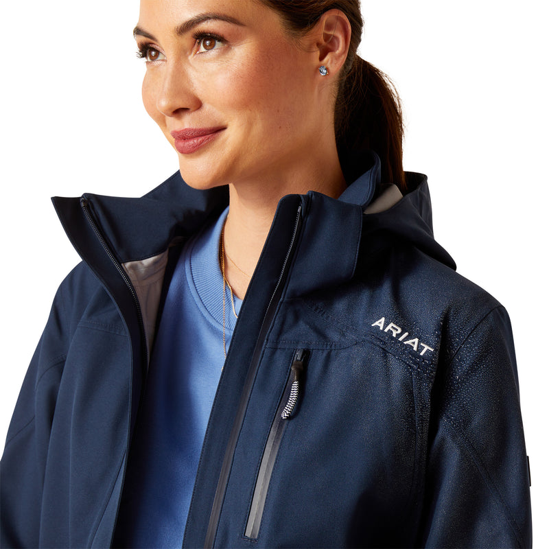 An image of a female model wearing the Ariat Coastal Long H20 Parka Jacket in the colour Navy Eclipse.