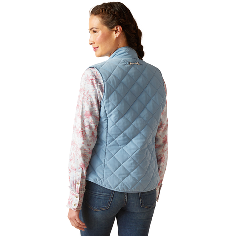 An image of a female model wearing the Ariat Woodside Quilted Gilet in the colour Blue Shadow.