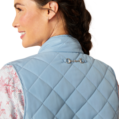 An image of a female model wearing the Ariat Woodside Quilted Gilet in the colour Blue Shadow.