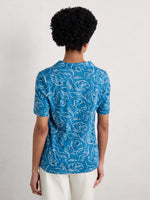 Seasalt Short Sleeve Misty Sky Shirt. A short sleeve T-shirt with collared V-neckline and all over camellia print on blue fabric.